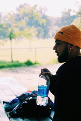 man wearing hat holding water bottle