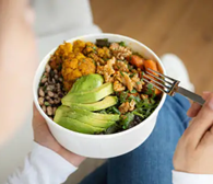 a bowl with a healthy meal of grains, protein, and vegetables